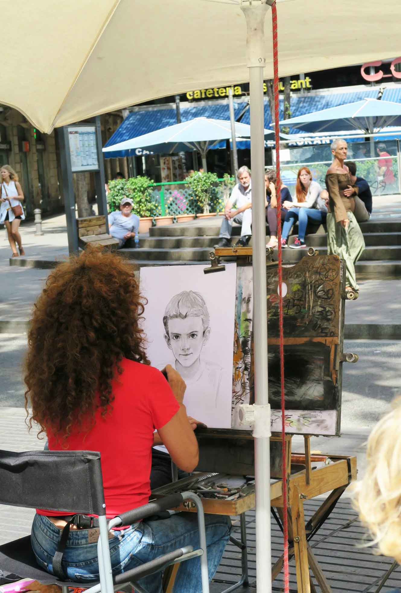 artist drawing a boy in Las Ramblas, Barcelona, Spain