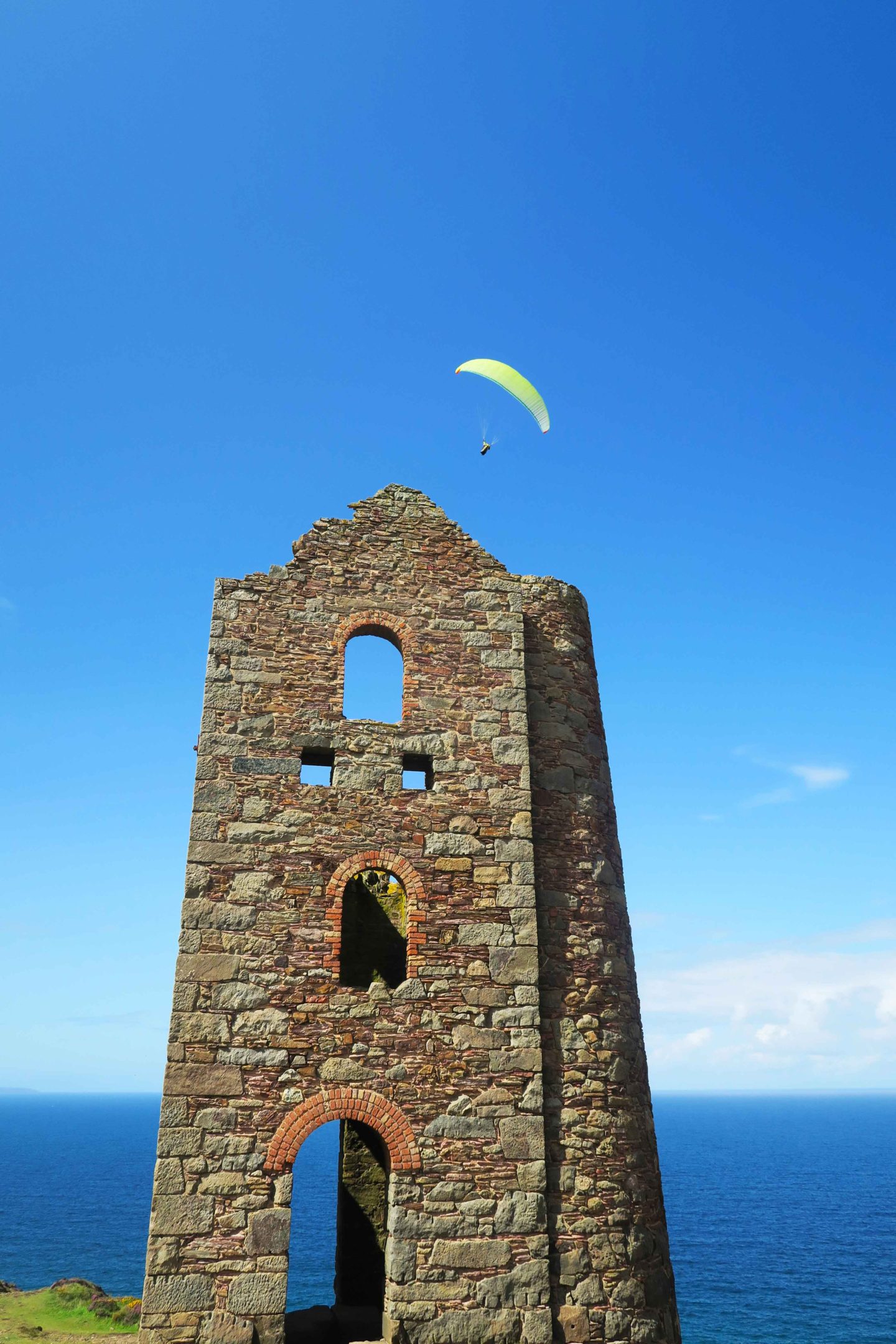 paraglider over national trust tin mine called wheal coates in cornwall