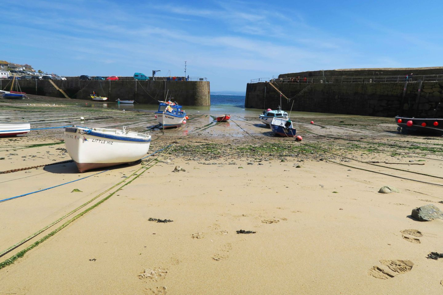 tide out with fishing boats at mousehole harbour in cornwall