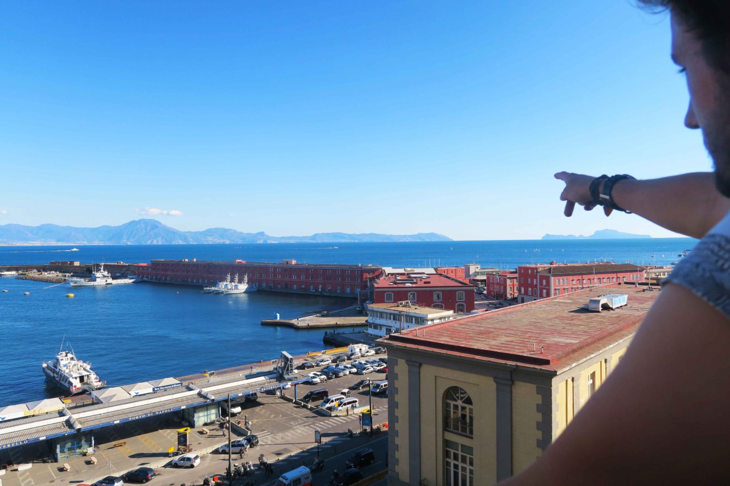 castel nuovo view with man point at the horizon in naples