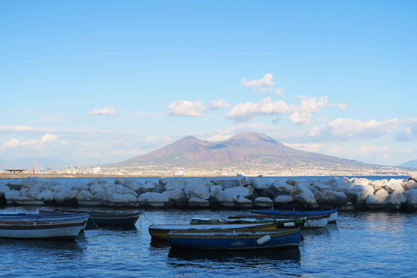 boats in the water at naples in front of mount vesuvius