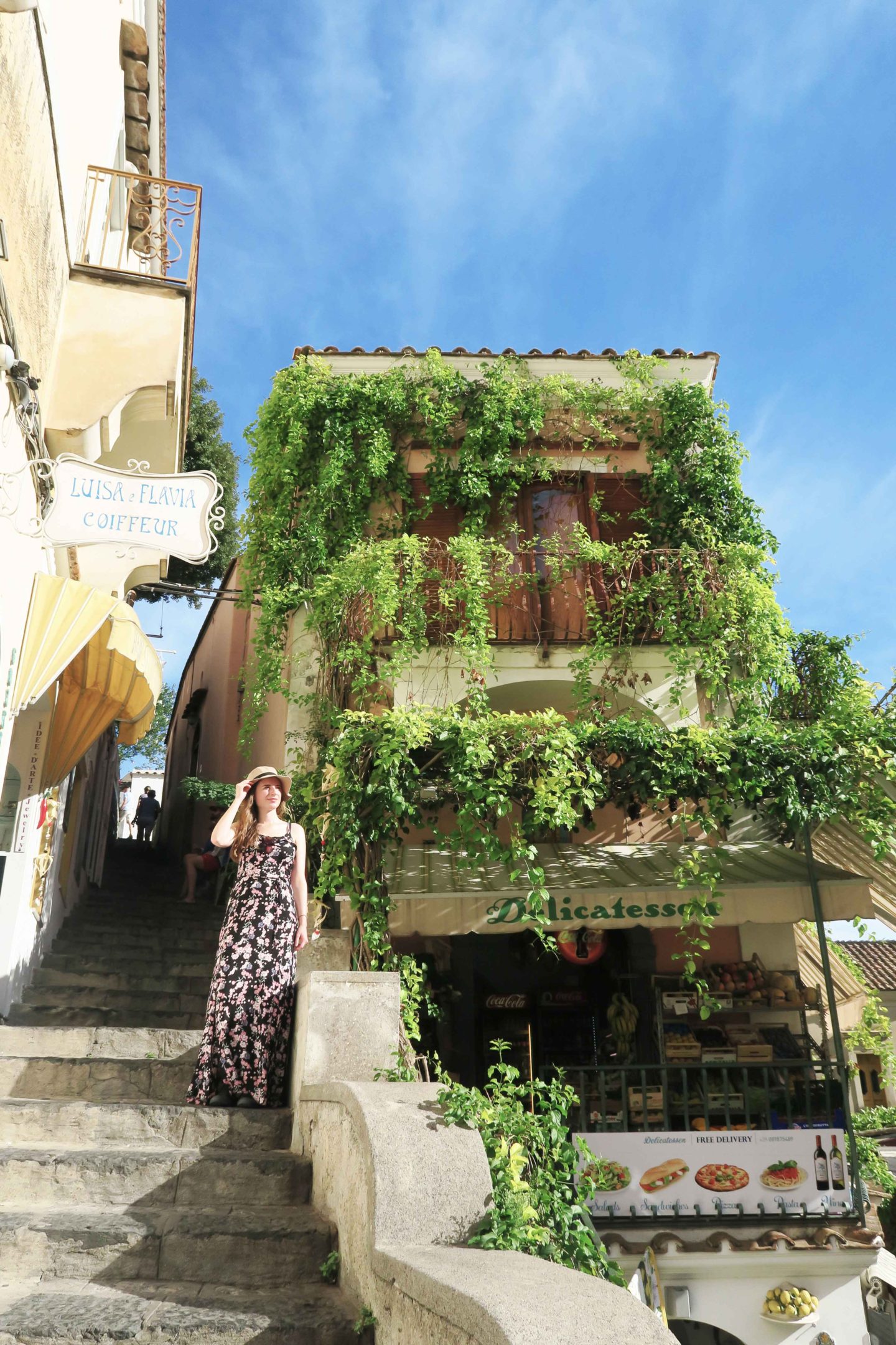 melissa carne standing on steps next to building in positano