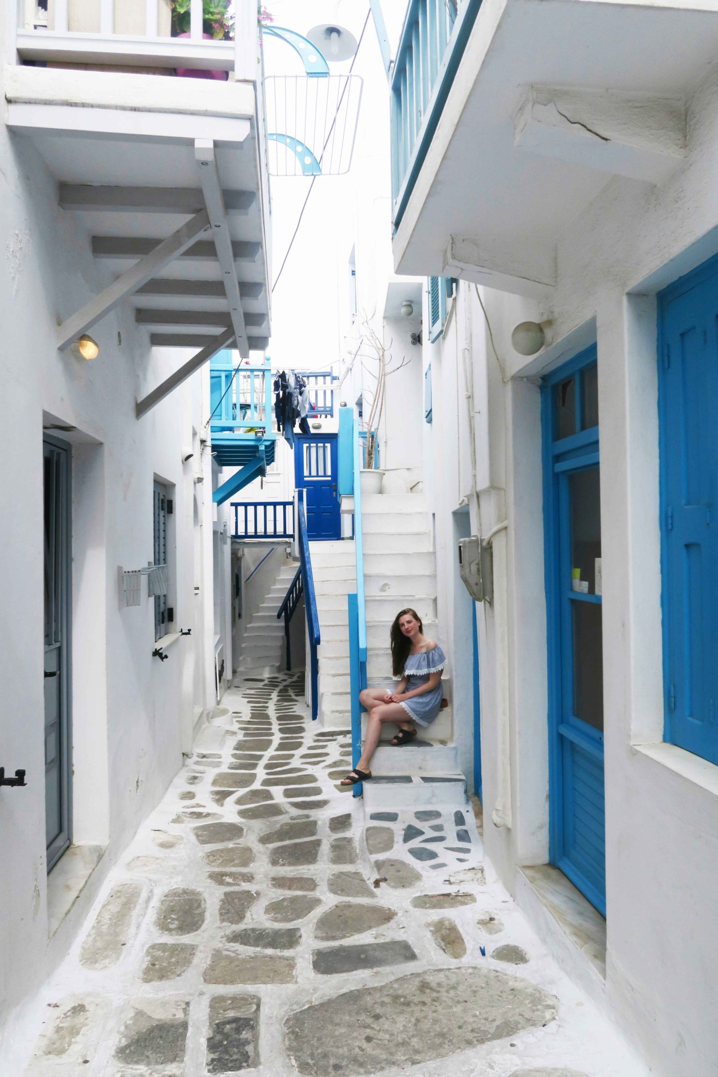 melissa carne sitting in white steps in mykonos town in greece