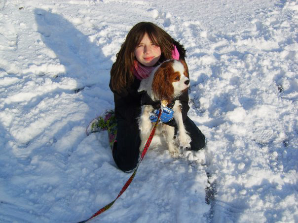 child in snow with dog