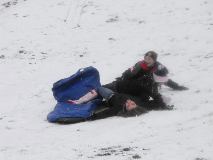 children falling of sled in snow