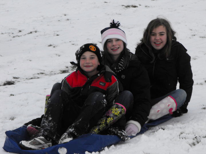 children on sled in snow