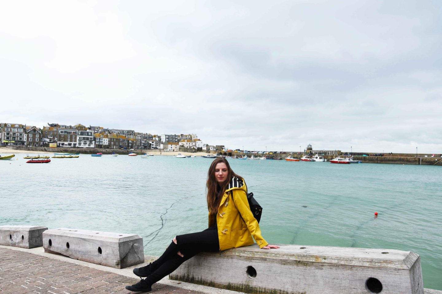 melissa carne sitting on wall at st ives harbour in cornwall