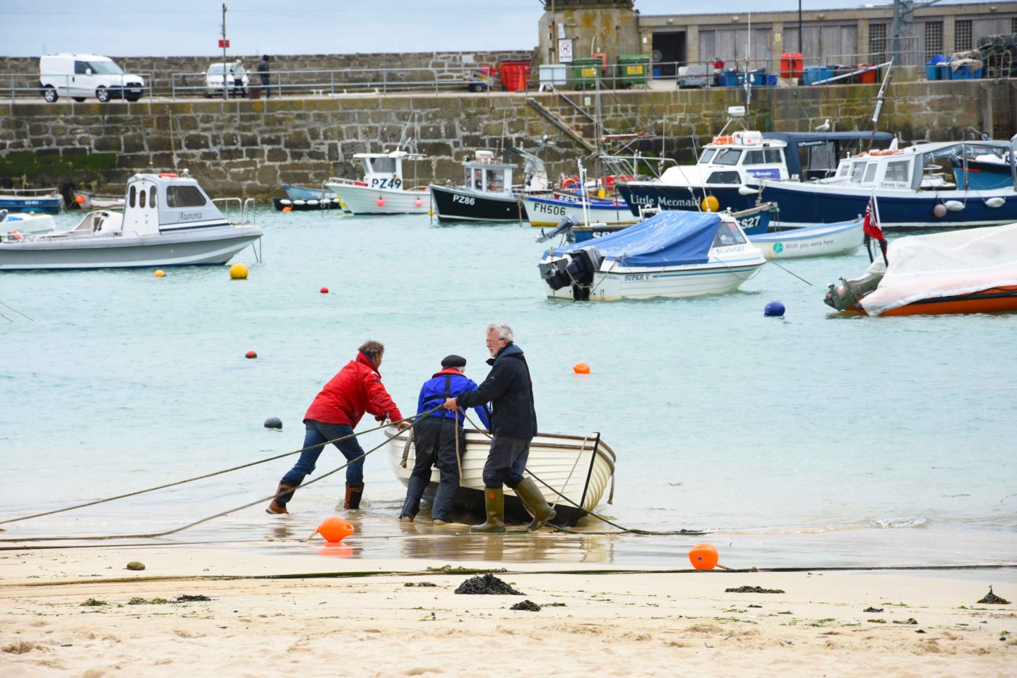 fisherman pulling boat in st ives harbour