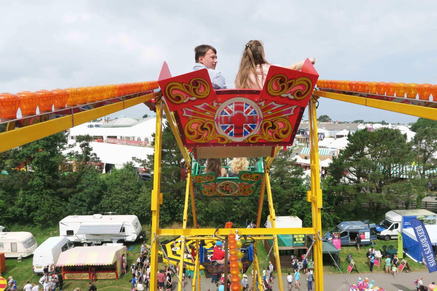 children on vintage ferris wheel at the fun fair in cornwall