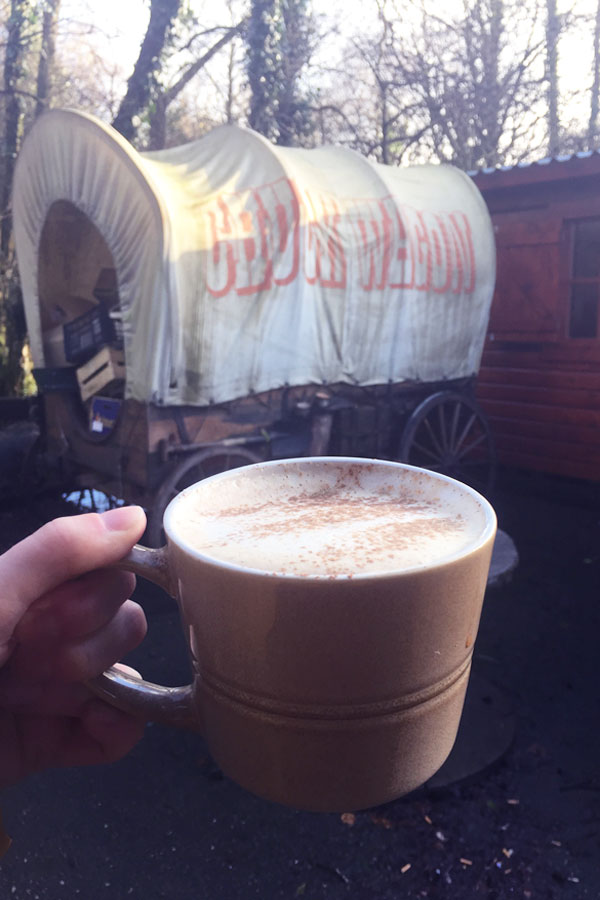 mug of chai latter in front of old band wagon