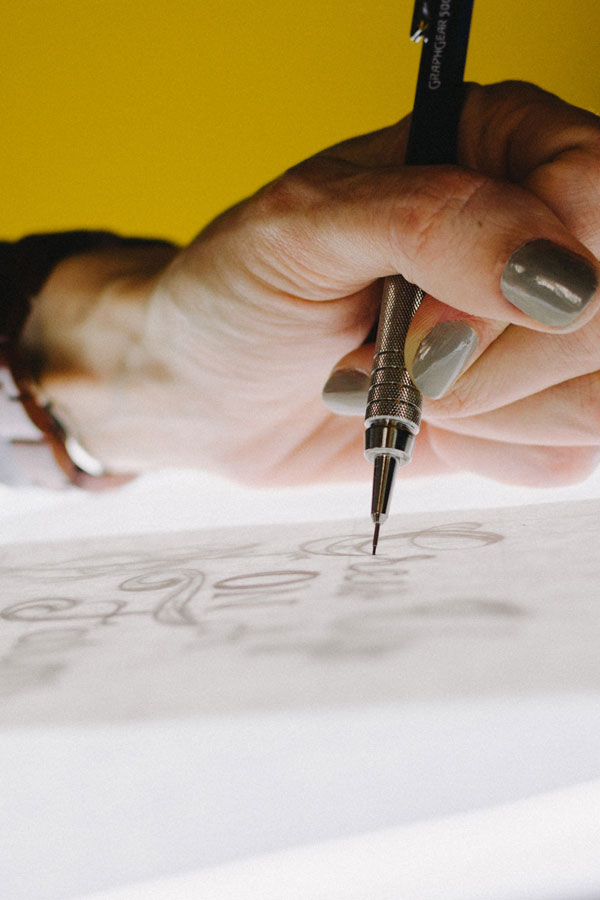 graphic designer drawing typography on a light box