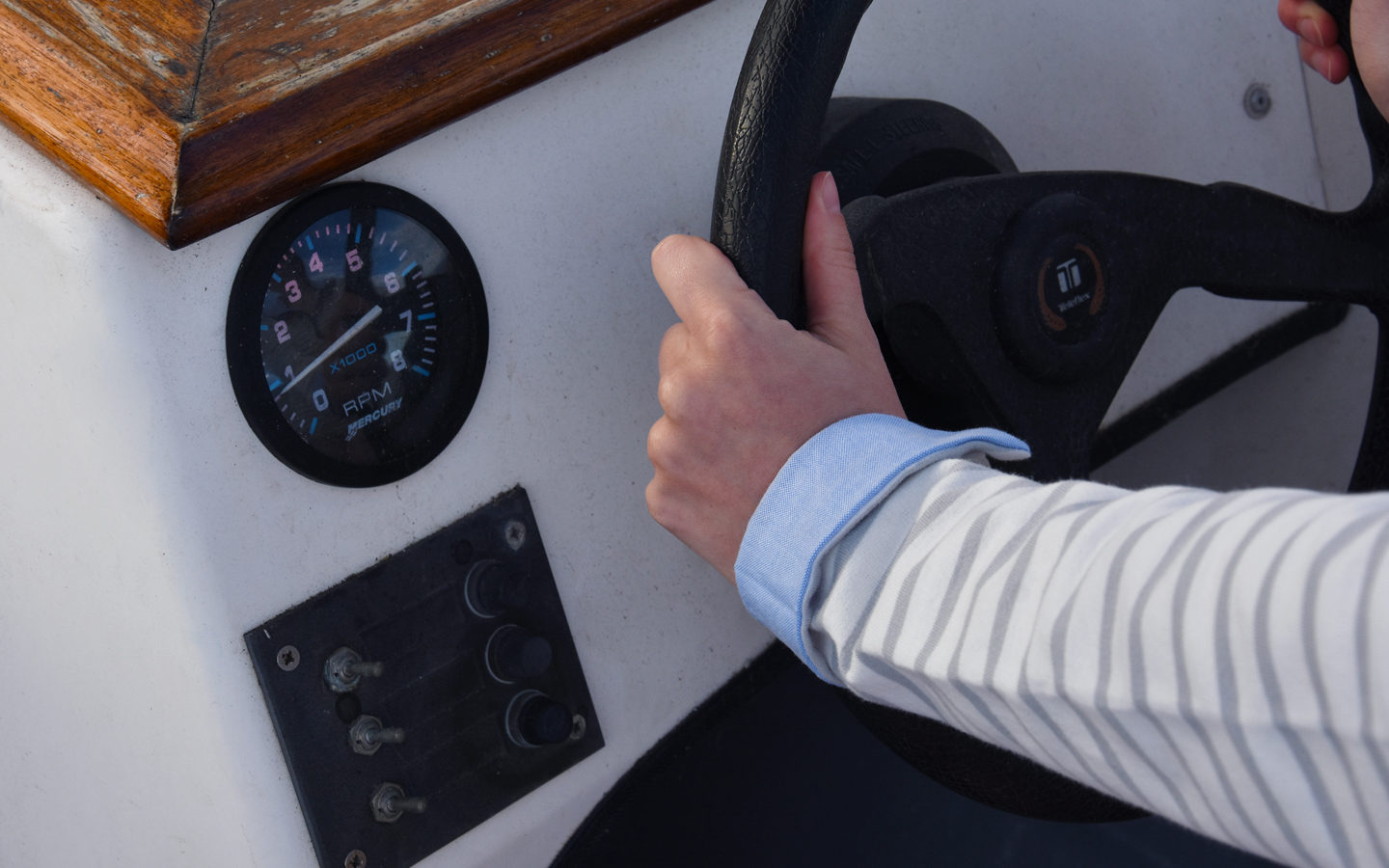 hand on a boat steering wheel