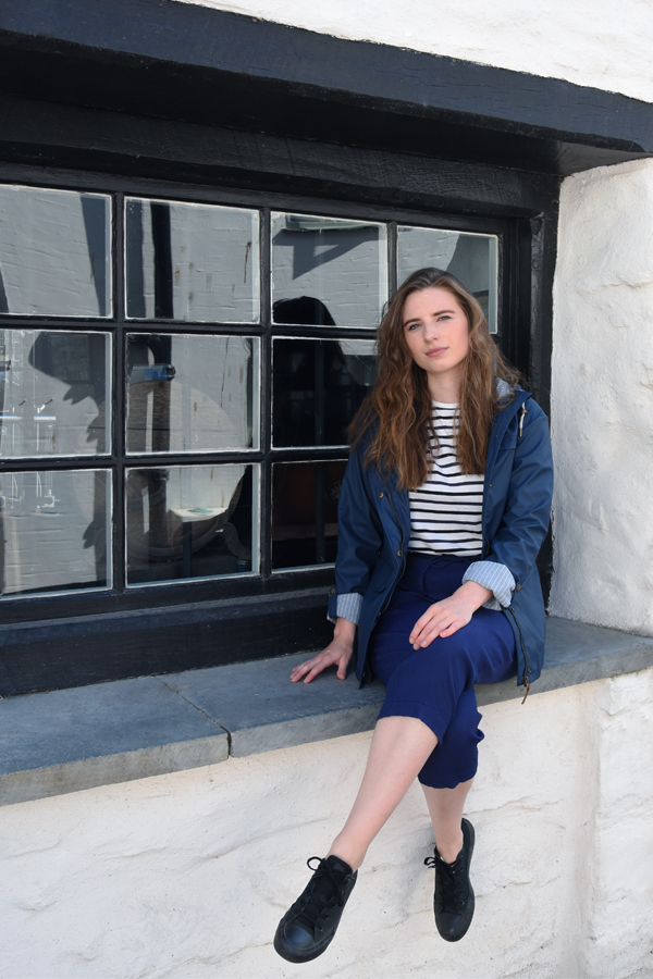 melissa carne sat on an old window sill in looe in cornwall wearing lighthouse clothing